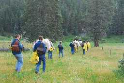 Leaving campsite for corral with slickers, saddle bags and pack horses